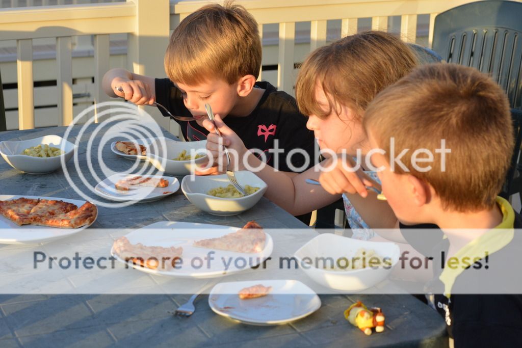 A group of people sitting at a table with a plate of food, with Dorset and Mess